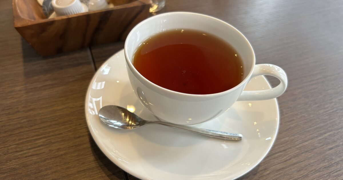 スプーン付きの白いカップの紅茶
