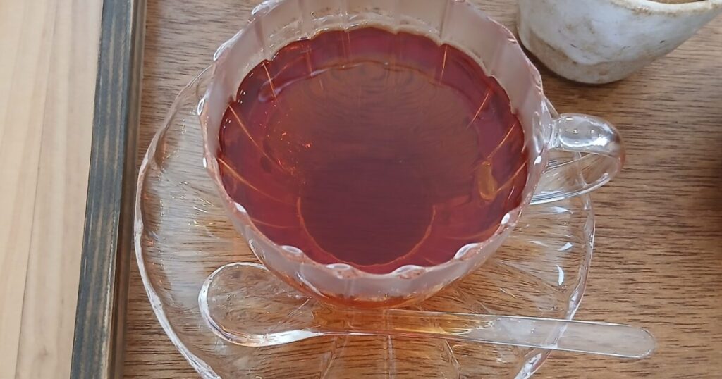 ガラスカップに注がれた紅茶とシュガーポット