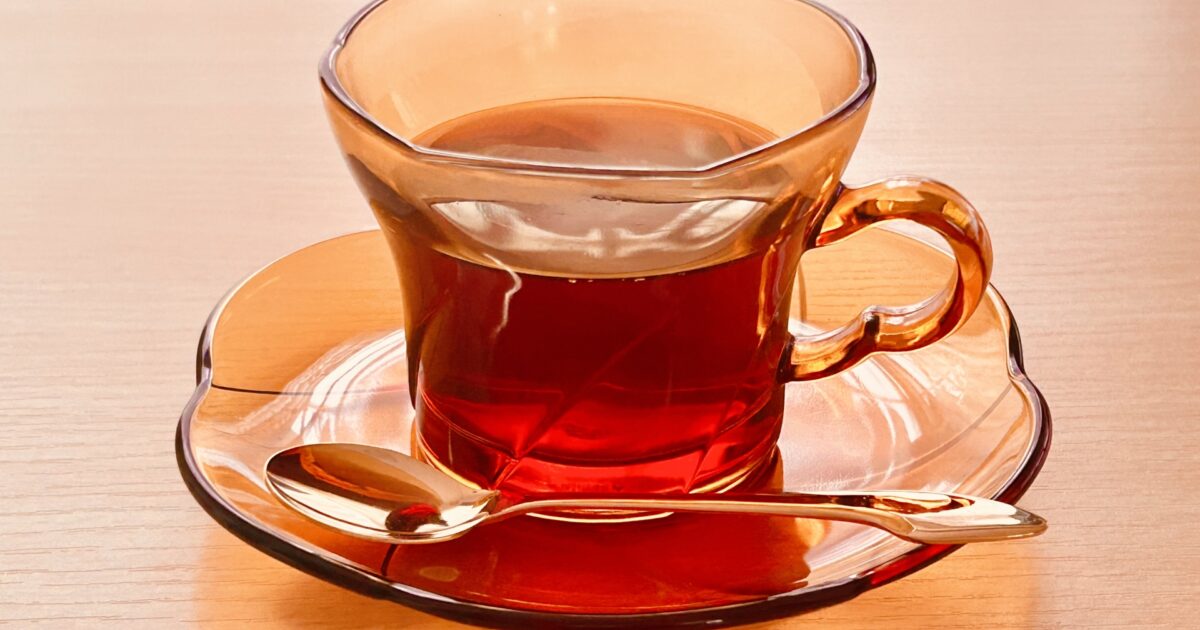 ゴールドスプーン付きのガラスカップの紅茶
