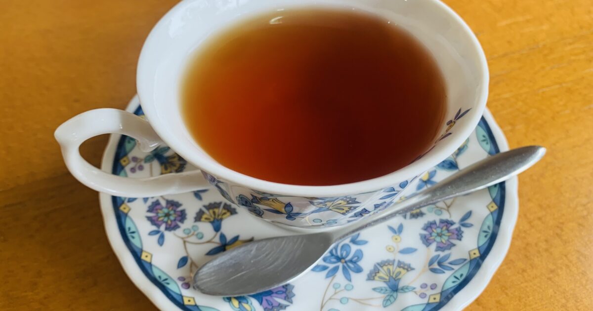 花柄のティーカップに入った紅茶とスプーン