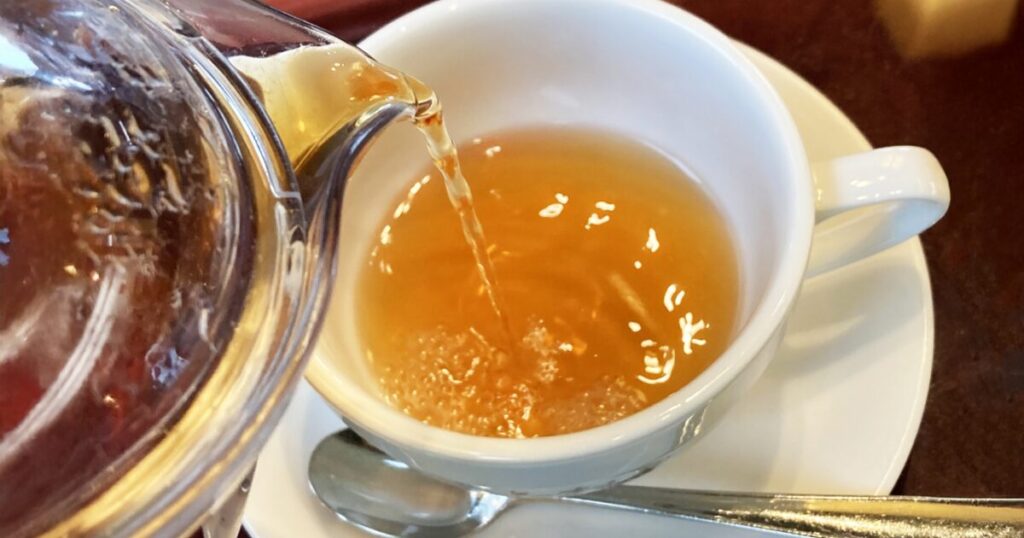 白いカップに紅茶を注ぐ瞬間のアップ