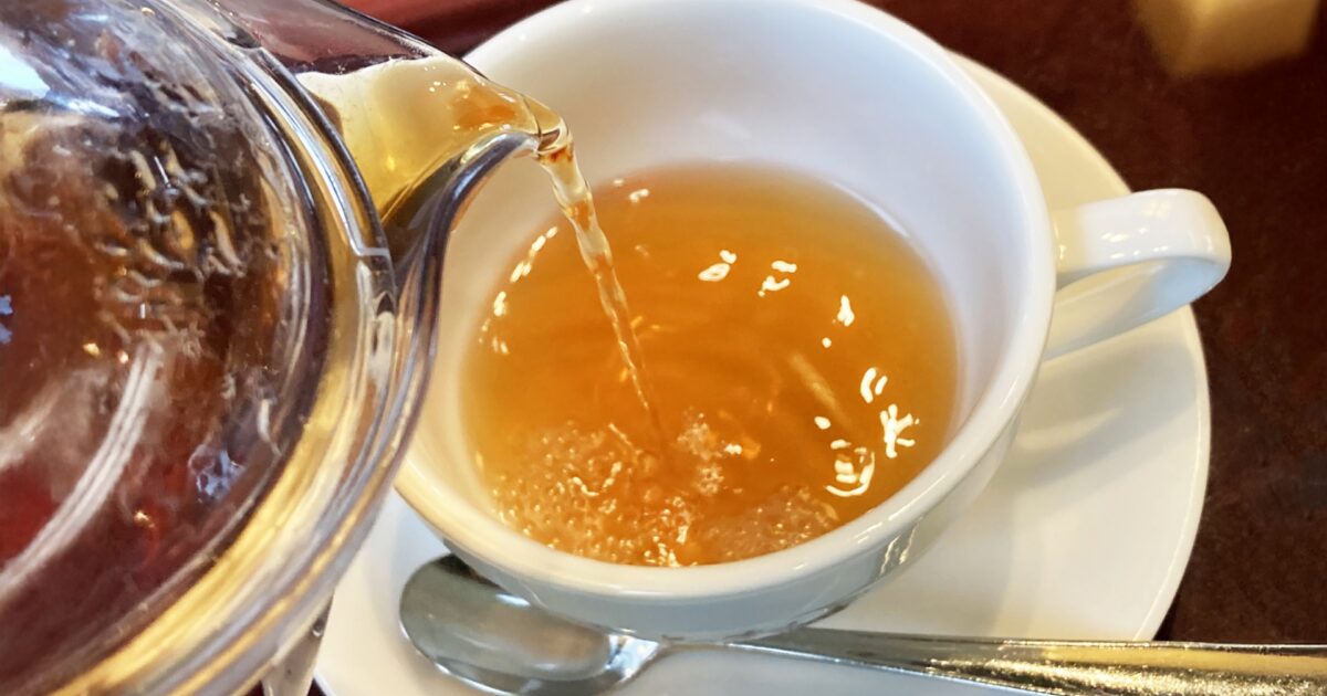 白いカップに紅茶を注ぐ瞬間のアップ