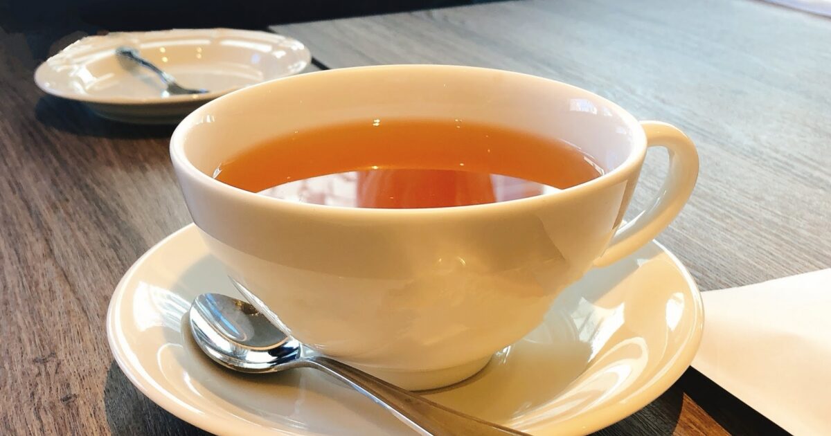 シンプルな白いカップに入った紅茶とスプーン